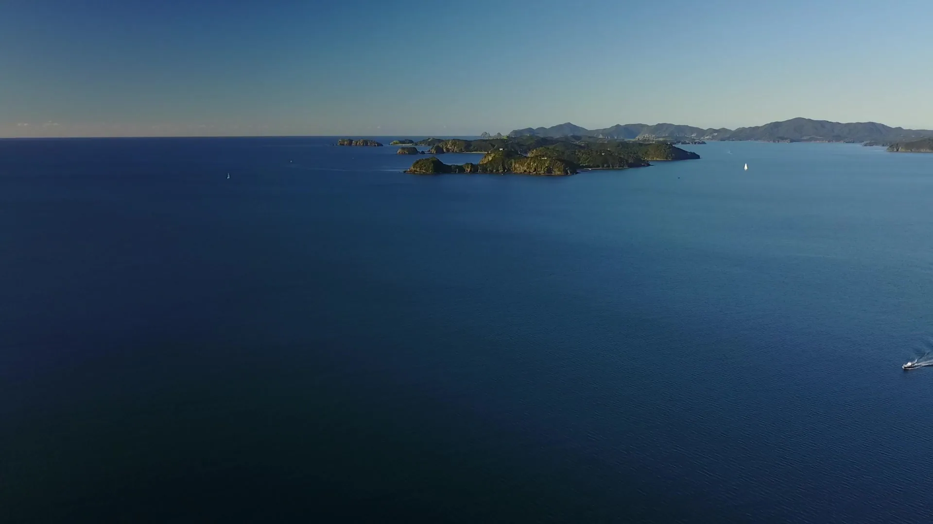 Aerial view of the Bay of Islands with green islands scattered across calm blue water