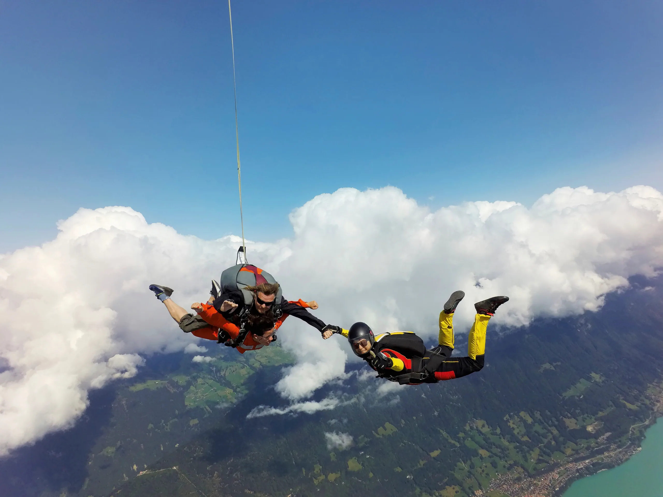 A tandem skydiver in freefall over Lake Taupō with Tongariro in the distance