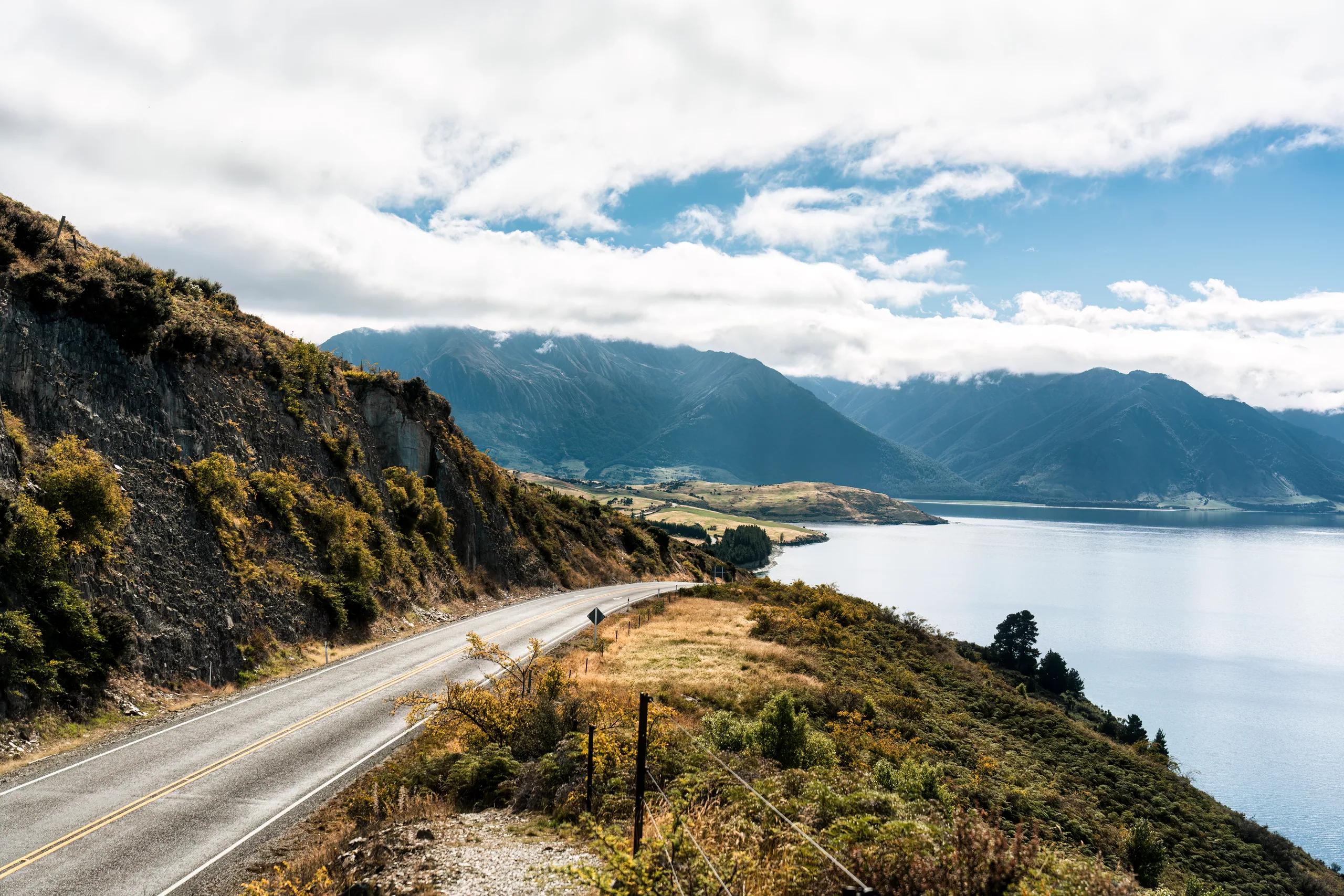 An empty road across the Canterbury Plains with the Southern Alps in the distance