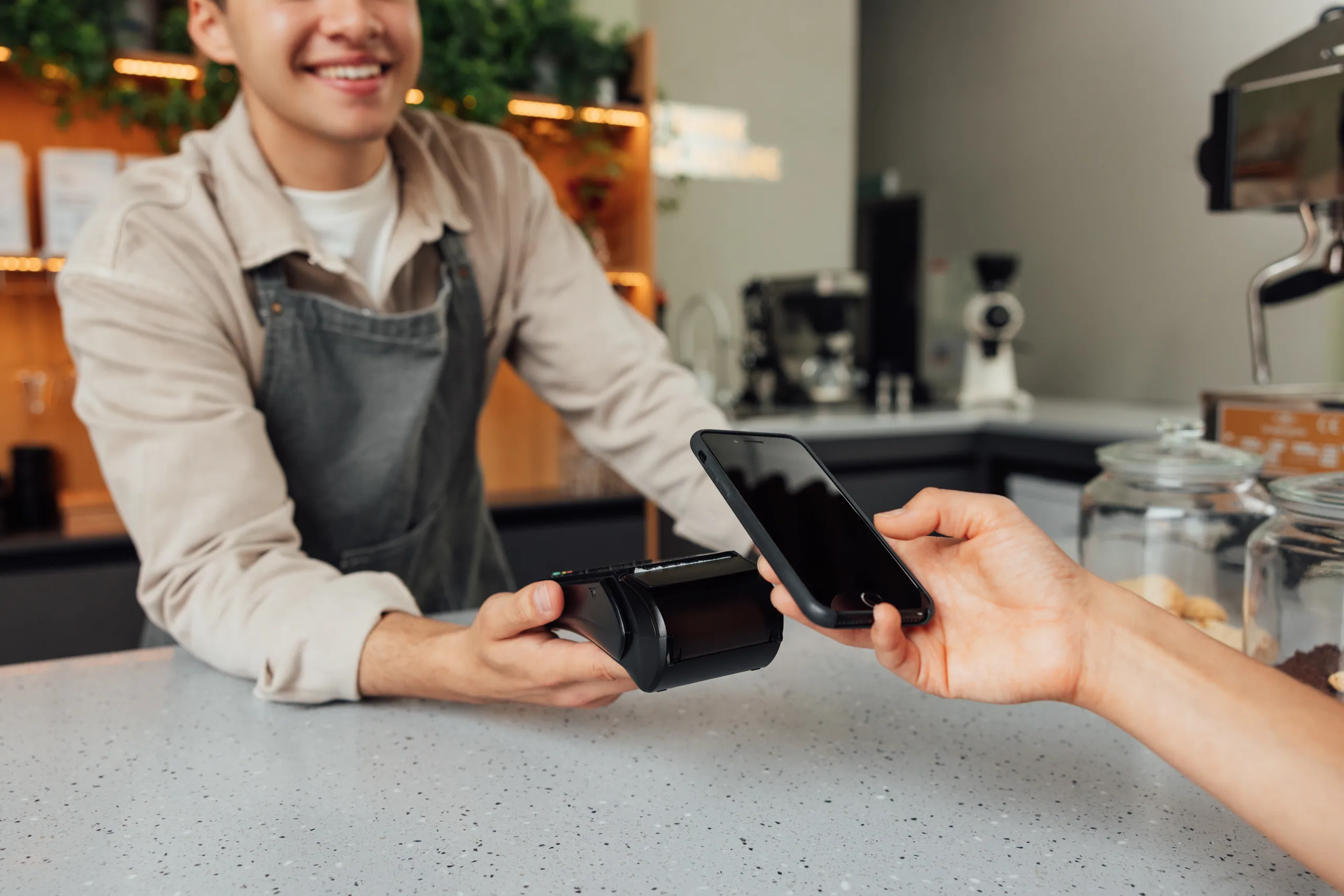 A customer paying for a coffee with a contactless card tap