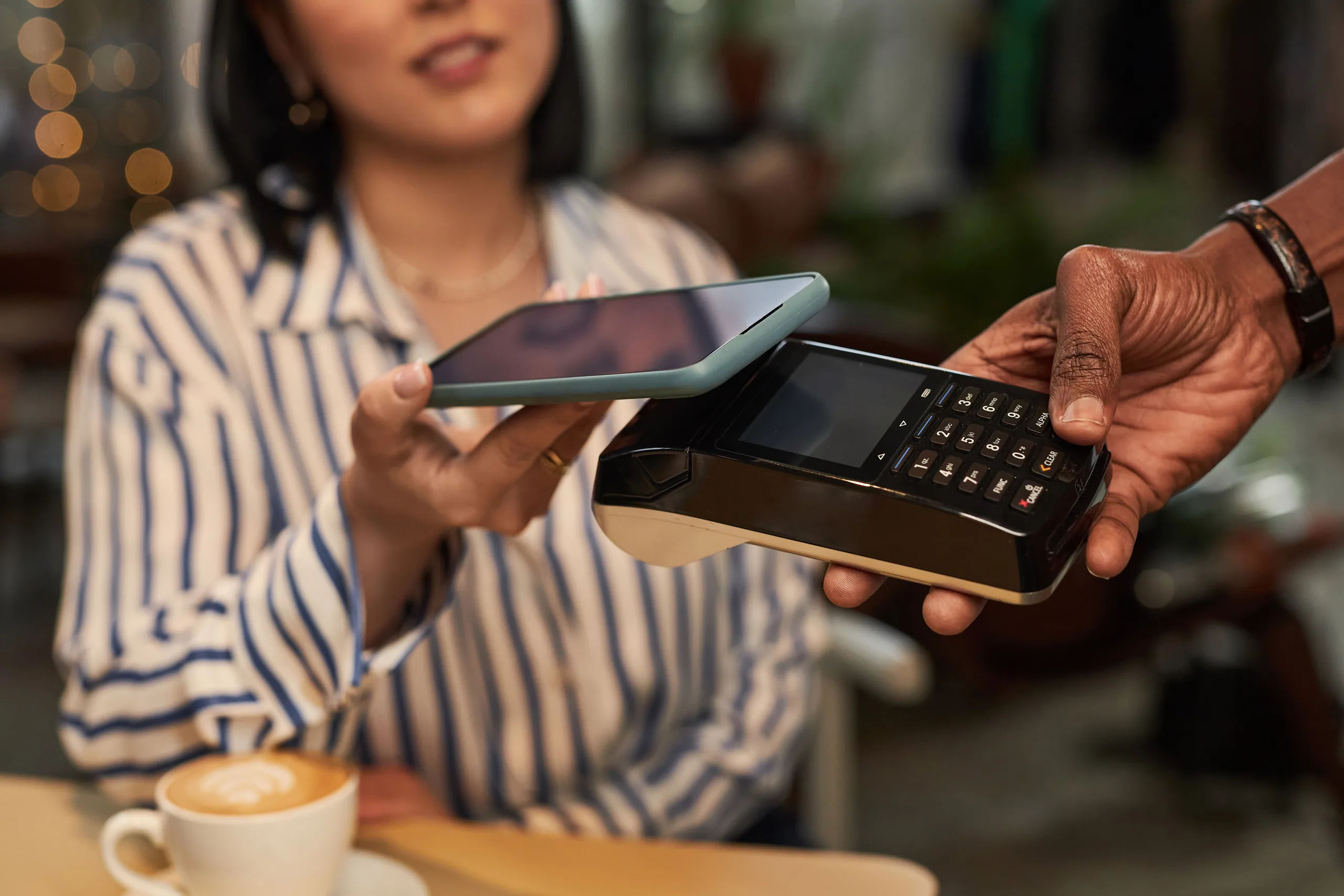 A traveller paying with a contactless card at a New Zealand cafe